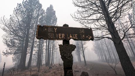 A sign damaged by the Bootleg Fire stands among the haze on July 22, 2021, near Paisley, Oregon.