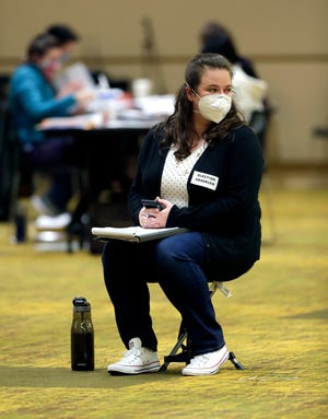 An election observer watches election workers at the Central Count for the city of Green Bay on Nov. 3, 2020, at the KI Convention Center.
