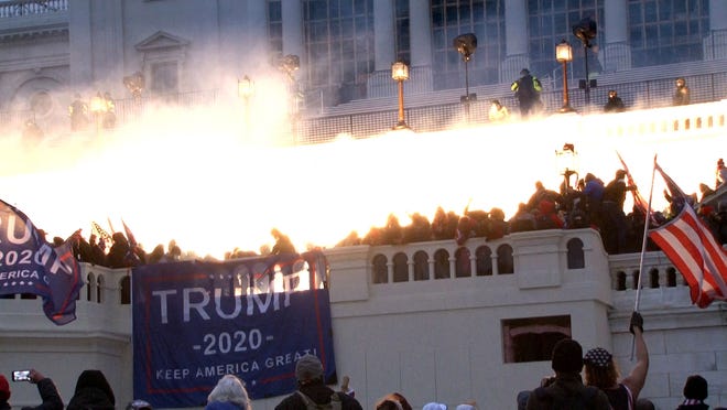 An explosion lights the west side of the U.S. Capitol as the pro-Trump mob is pushed back on the evening of Jan. 6, 2021.