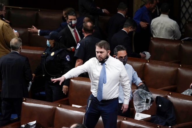 Rep. Ruben Gallego, D-Ariz., stands on a chair as lawmakers prepare to evacuate as protesters try to break into the House chamber at the U.S. Capitol on Jan. 6, 2021, in Washington.