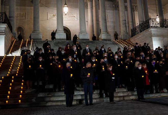 House Speaker Nancy Pelosi, bottom center, and Senate Majority Leader Chuck Schumer, bottom second from left, and House Majority Leader Steny Hoyer, bottom left, along with other members of Congress take part in a vigil marking one year since the attack on the U.S. Capitol that happened on January 6, 2021.