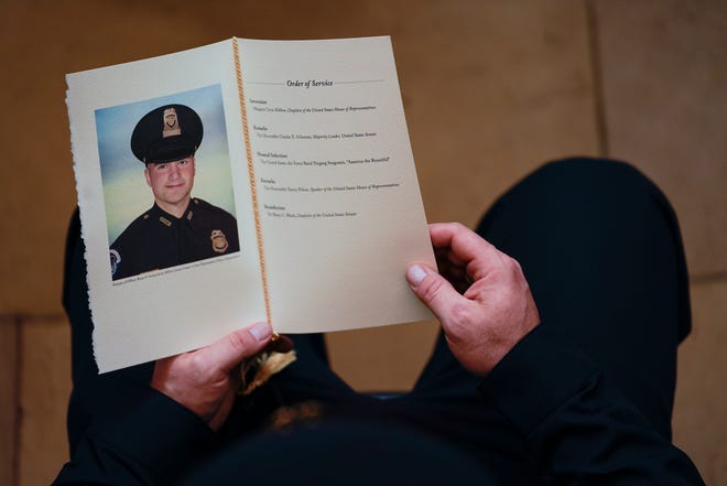 A U.S. Capitol Police Officer holds a program during a ceremony memorializing U.S. Capitol Police officer Brian Sicknick on Wednesday, Feb. 3, 2021, in Washington, D.C.