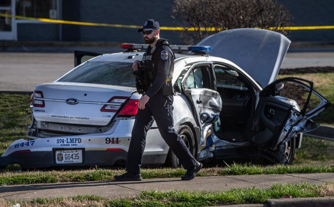 A Louisville Metro Police patrols car was involved in an accident at Cane Run Road and South Crums Lane. A police officer walks past the patrol car. March 17, 2022