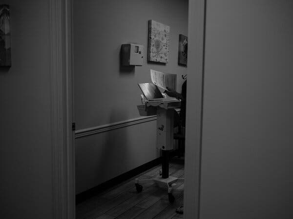 Dr. Dennison in an examination room, wheeling a laptop from patient to patient. Twenty years ago, 1 percent of her cases related to mental and behavioral health, she estimates; now at least 50 percent do.
