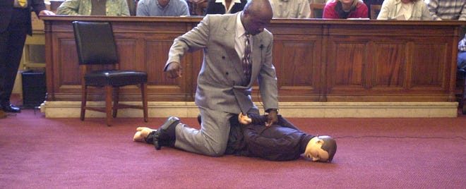 Cincinnati Police Officer David Hunter demonstrates how he saw fellow police officer Patrick Caton straddle a handcuffed Roger Owensby Jr. and repeatedly punch him while he was on the ground, during the 2001 trial of Officer Robert Jorg.